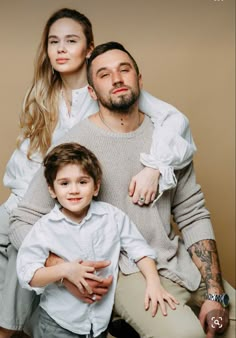 a man and woman sitting next to a little boy