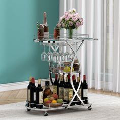 a bar cart with wine glasses and bottles on it