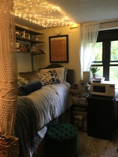 a bed room with a neatly made bed and lots of lights on the wall above it