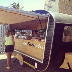 a woman standing next to a food cart