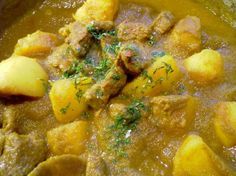 a bowl filled with meat and potatoes on top of a table