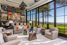 a living room filled with lots of furniture and large windows that look out onto the golf course