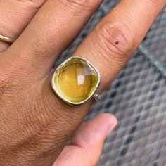 This Exclusive Lemon Topaz Ring Features A 16mm Checkered Cut Lemon Topaz Cushion Cabochon Set In A Sterling Silver Bezel On A 2mm Round Hammered Band. The Back Is Imprinted With 925 As A Stamp Of The Sterling's Authenticity And Durability. Available In Whole And Half Sizes. Designed In Massachusetts And Handcrafted In India, With High-Quality Materials And Ethically Sourced Stones. Product Specifications: Lemon Topaz Gemstone 925 Silver Hammered Band Sterling Silver Bezel Yellow Topaz Round Ring, Modern Yellow Citrine Jewelry, Modern Yellow Ring Jewelry, Yellow Citrine Gemstone Rings, Faceted Yellow Citrine Jewelry, Yellow Faceted Citrine Jewelry, Modern Yellow Gemstone Rings, Polished Yellow Topaz Ring, Classic Yellow Faceted Rings