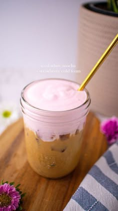 a jar filled with food sitting on top of a wooden cutting board next to flowers