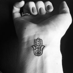 a hand with a hamsa tattoo on it