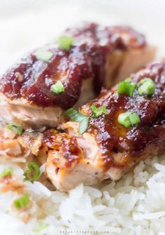 chicken with bbq sauce on top of rice and garnished with scallions