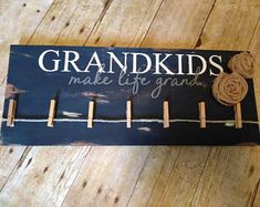 a wooden sign that says grandkids make life grand with clothes pins attached to it