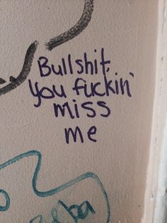 graffiti on the side of a wall with words written in blue and green ink,