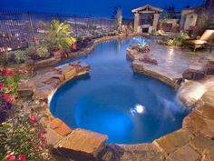 an outdoor swimming pool surrounded by landscaping