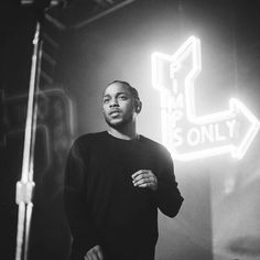 a man standing in front of a neon sign