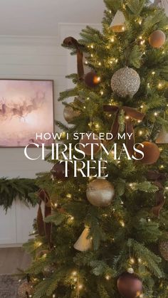 a christmas tree with lights and ornaments on it in front of a painting that says how i styled my christmas tree