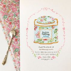 a greeting card featuring a jar with flowers on it and a spoon next to it