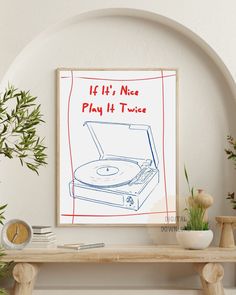 a record player is sitting on top of a table next to a potted plant