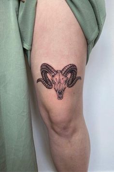 a ram skull tattoo on the thigh