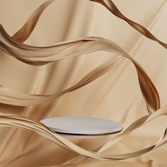 a white plate sitting on top of a table next to a wall covered in flowing hair