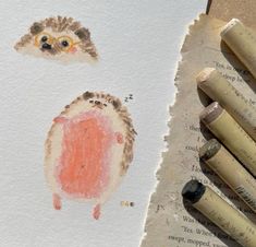 some crayons are laying on top of a piece of paper with an owl drawn on it