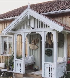 a small white house with a porch and windows