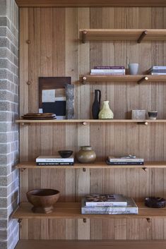 a wooden shelf filled with books and vases