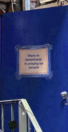 a blue door with a sign that says there is something in praying for people