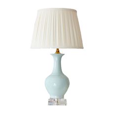 a light blue lamp with a white shade on it