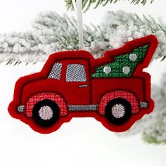 a red truck ornament hanging from a christmas tree