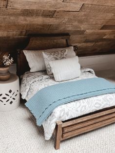 a bed sitting under a wooden ceiling next to a white vase with flowers on it