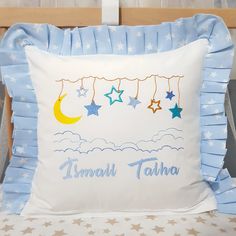 a blue and white pillow with stars hanging from it