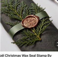 a wax seal stamp on top of a christmas tree branch