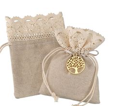 two bags with lace and a tree on the front one has a gold brooch