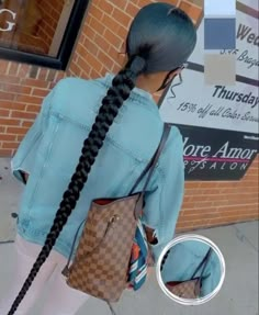 a woman with long black hair wearing a blue jean jacket and carrying a brown louis vuitton bag