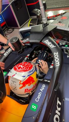 a man sitting in a racing car with his helmet on