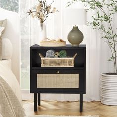 a black shelf with baskets and towels on it next to a bed in a room