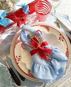 a table set for christmas with plates and silverware, napkins and candy canes