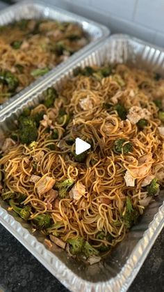 two plastic trays filled with noodles and broccoli on top of a counter