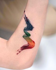 a woman's arm with a colorful tattoo on the left side of her arm