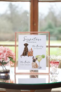 there is a card on top of a table with wine glasses and flowers in the background