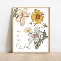 an art print with flowers and the words, you are so loved in gold foil