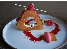 a white plate topped with a piece of cake and raspberries