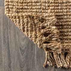 a close up view of a rug on the floor with wood grains in the background