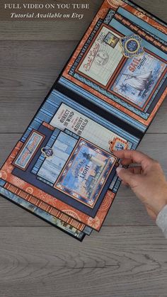 a person holding an open book on top of a wooden floor