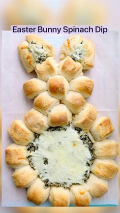 bread rolls with cheese and spinach spread on top, arranged in the shape of a flower