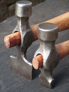 an old pair of hammers sitting on top of a wooden table