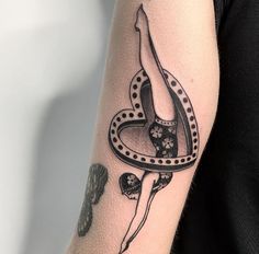 a woman's arm with a black and white tattoo design on the left forearm