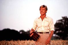 a man standing in the middle of a wheat field