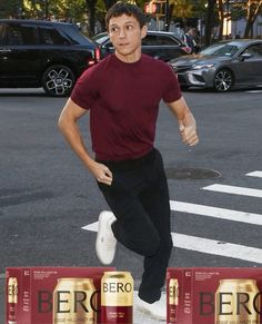 a man running in the street with three beer cans behind him and an advertisement for bergo