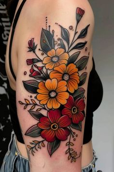 a woman's arm with flowers and leaves tattooed on the back of her shoulder