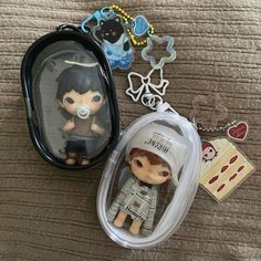 a little boy with a pacifier in a case and some keychains on a bed