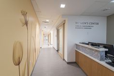 a long hallway leading to a women's center with flowers painted on the wall