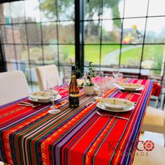 the table is set with plates and wine glasses on it, along with other place settings