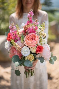 a woman holding a bouquet of flowers in her hands